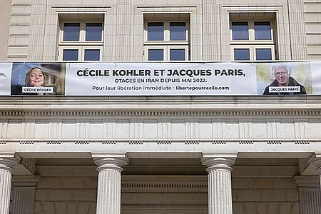 photo de la banderole portant l'inscription "Cécile Kohler et Jacques Paris, otages en Iran depuis 2022. Pour leur libération immédiate. libertepourcecile.com"