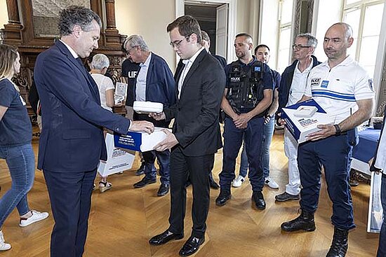 Photo du maire remettant un défibrillateur à des citoyens, dont des policiers municipaux.