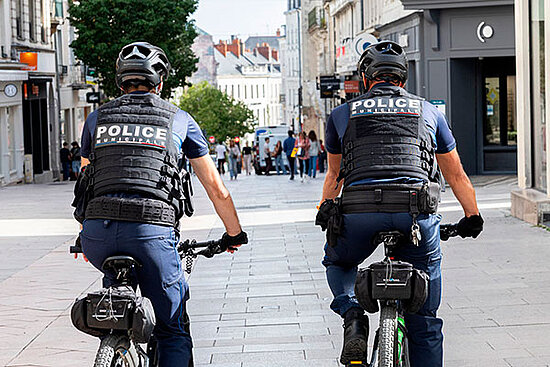 Deux policiers &agrave; v&eacute;lo, de dos, dans une rue commer&ccedil;ante du plateau pi&eacute;tonnier d'Angers.