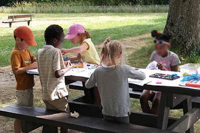 Des enfants en atelier dessin dans le parcd e l'accueil de loisirs de la Claverie