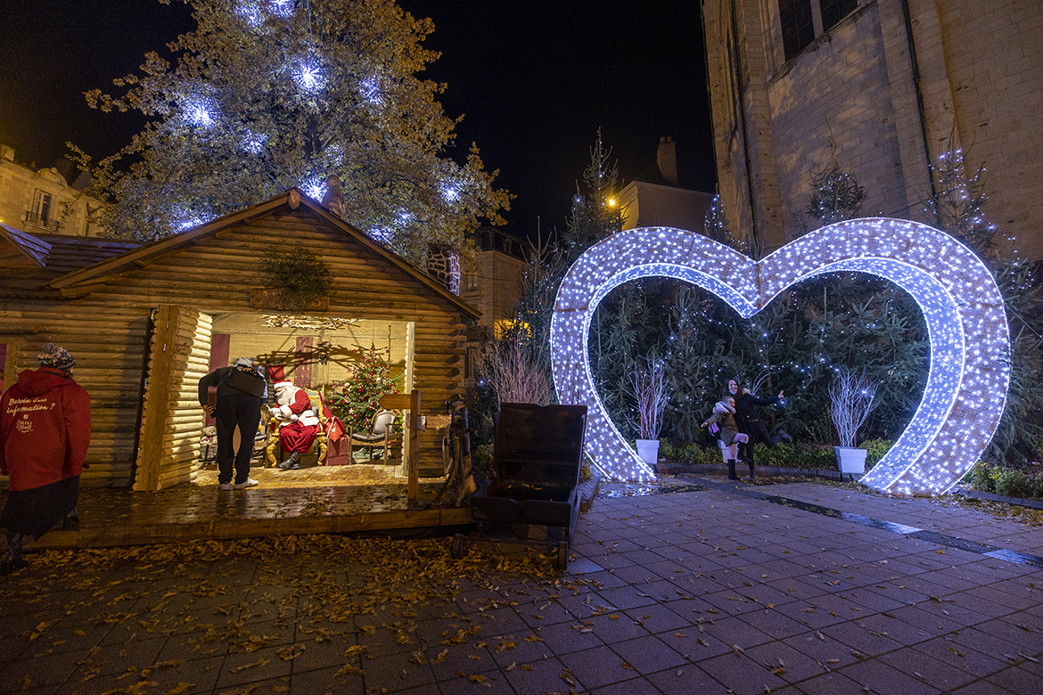 Photo de la place Sainte-Croix &agrave; Angers, avec la maison du P&egrave;re No&euml;l et l&#039;arche lumineuse en forme de coeur.